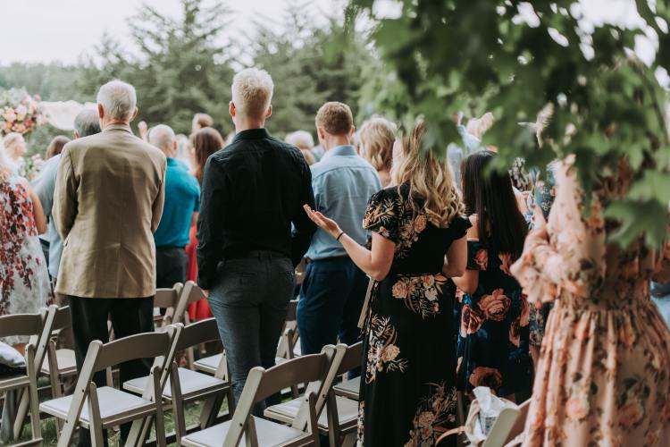 Rooted Weddings | Eloquent Package | Guests standing at wedding ceremony - Photo by Samantha Gades from Unsplash